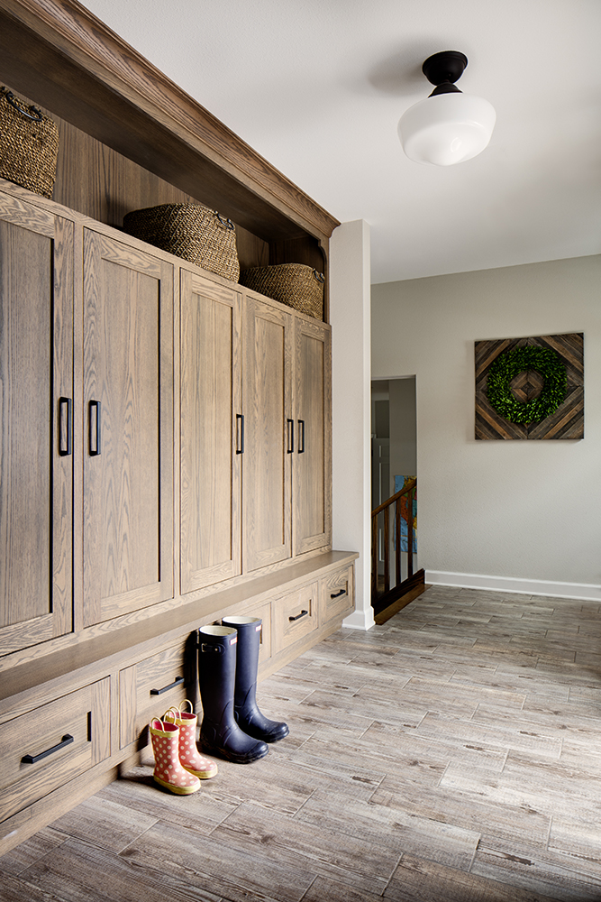 corridor with wood cabinetry and boots at foot of cabinets