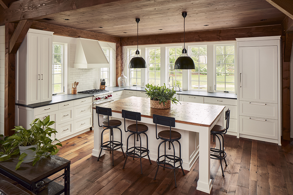 kitchen with white cabinetry, wood floor and ceiling, large windows, and island with wood counter top and four chairs