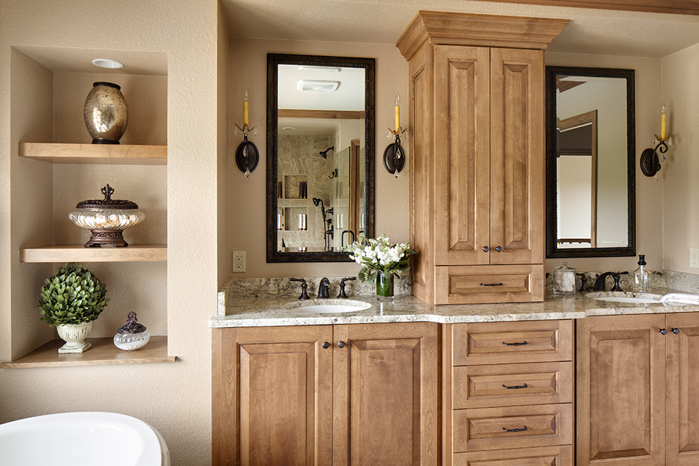 bathroom with light wood cabinetry and shelving, with dual vanities